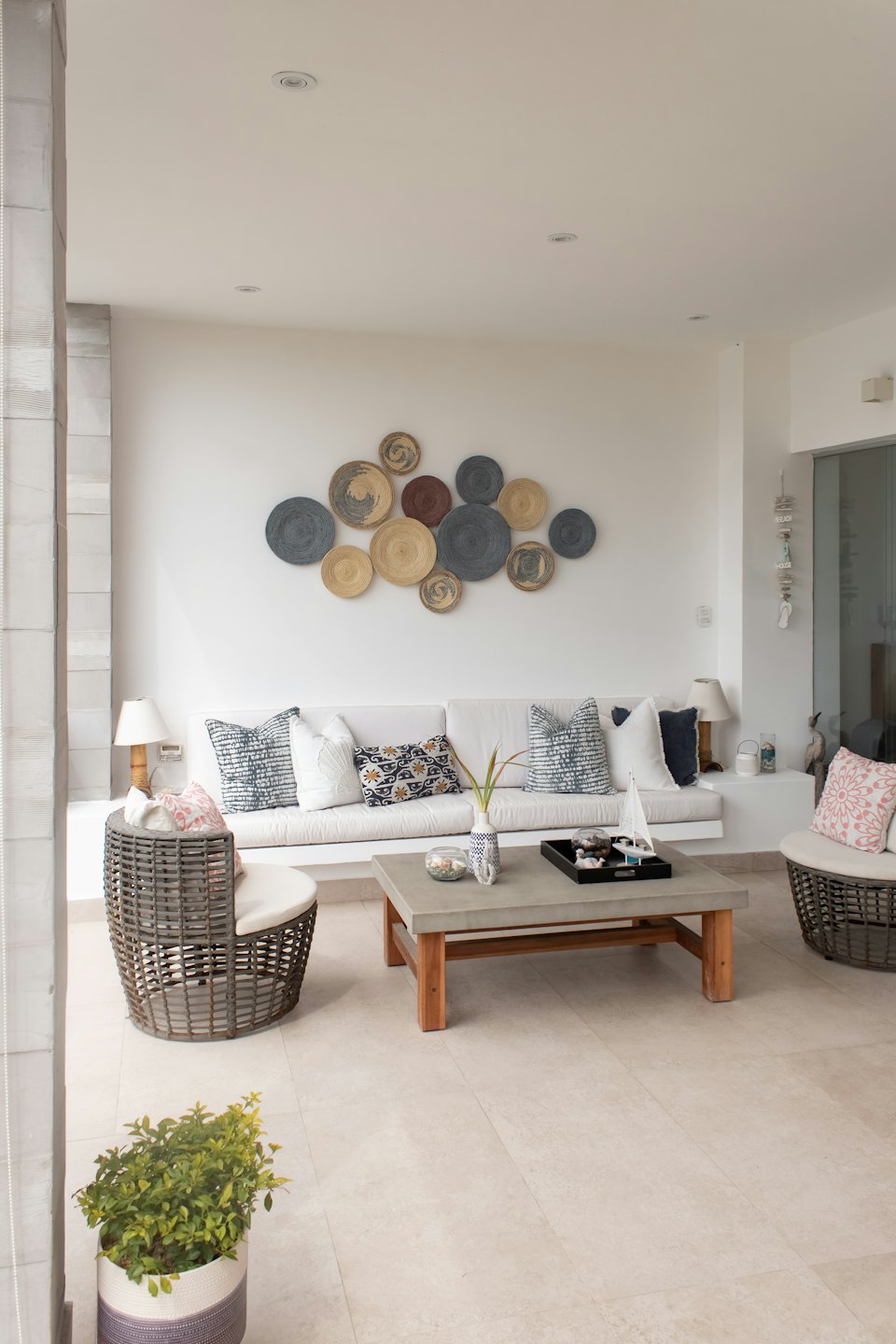 Living room with white sofa and wicker chairs.