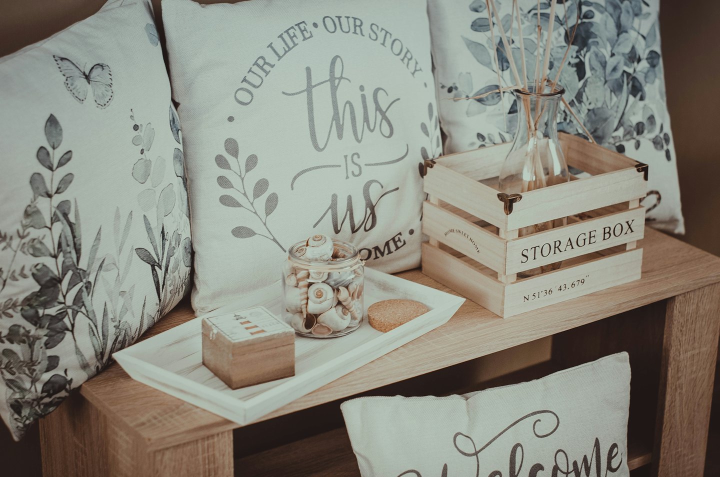Decorative pillows and decor items resting on a wooden bench.